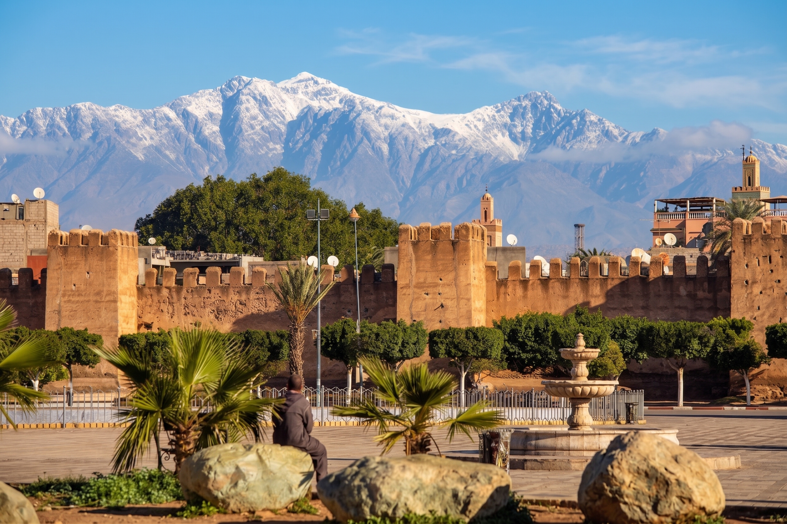 View of the historic mudbrick ramparts of Taroudant against the snow-capped High Atlas mountains in Morocco.